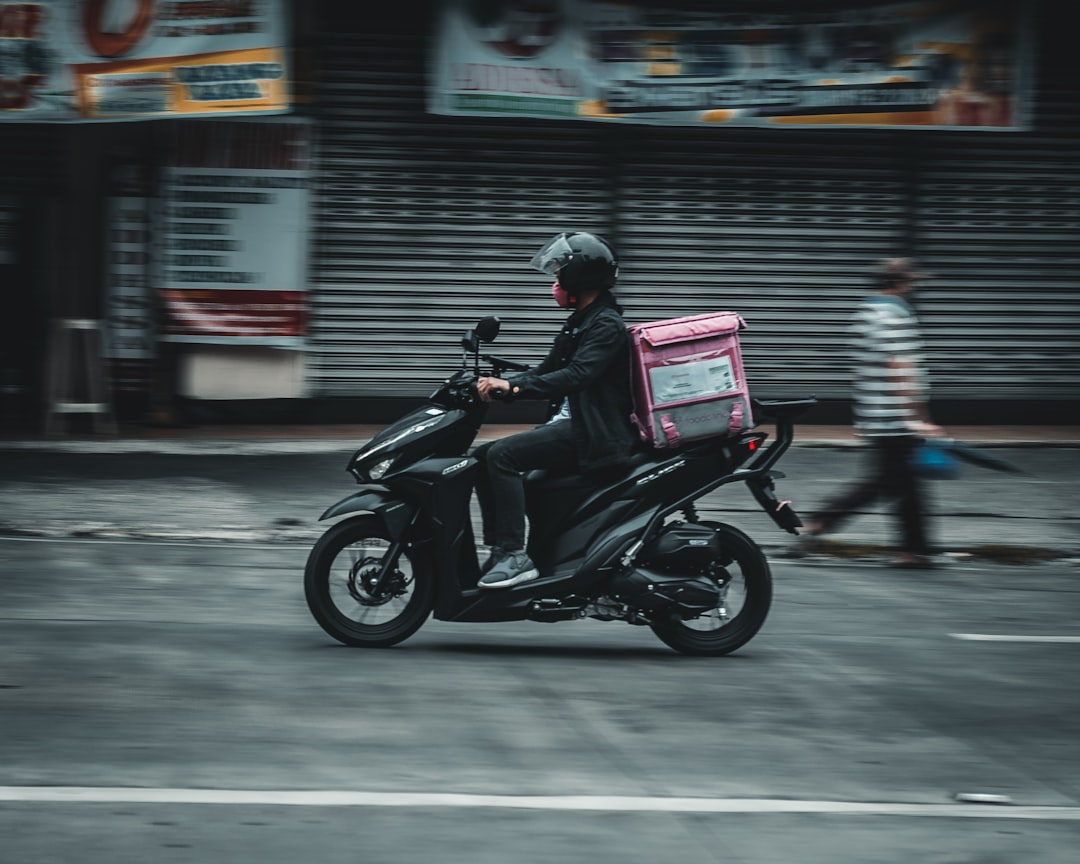 a-man-riding-a-motorcycle-down-a-street-kqo8p16y0yy